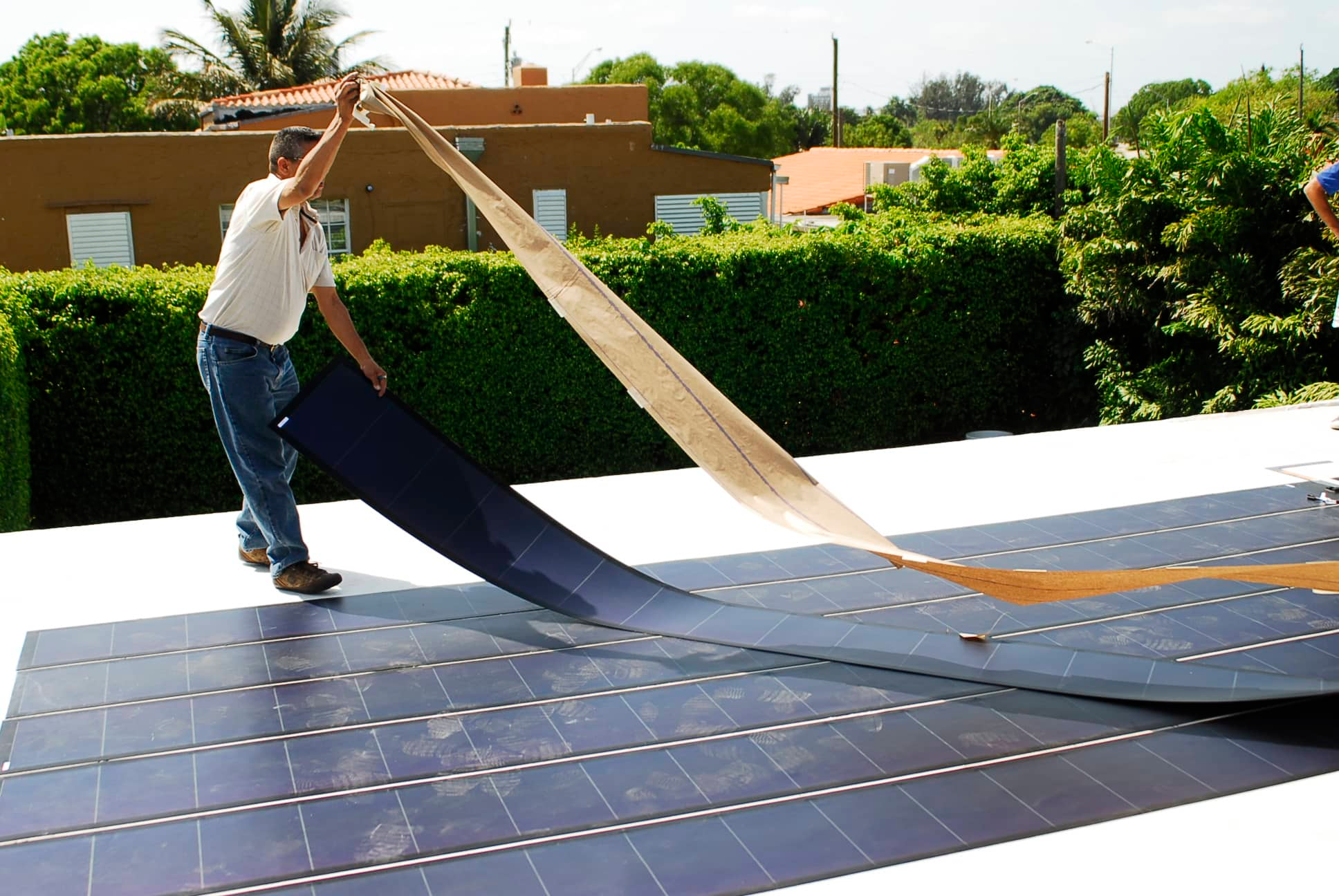 Man laying down flexible solar panels.